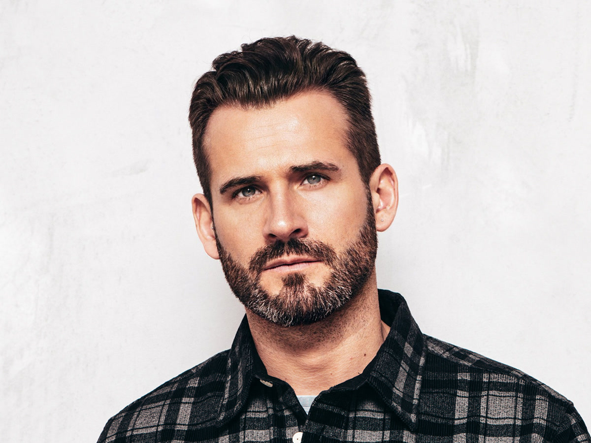 Portrait of a man with thick, well-groomed hair and a full beard
