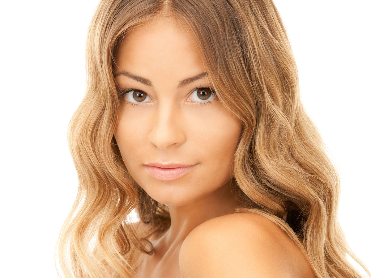 Portrait of a woman with smooth, radiant skin and soft wavy hair